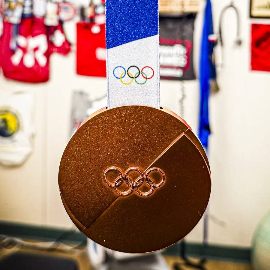 Olympic bronze medal from the 2026 Milano Cortina Winter Olympics, displayed at Mui Chiropractic